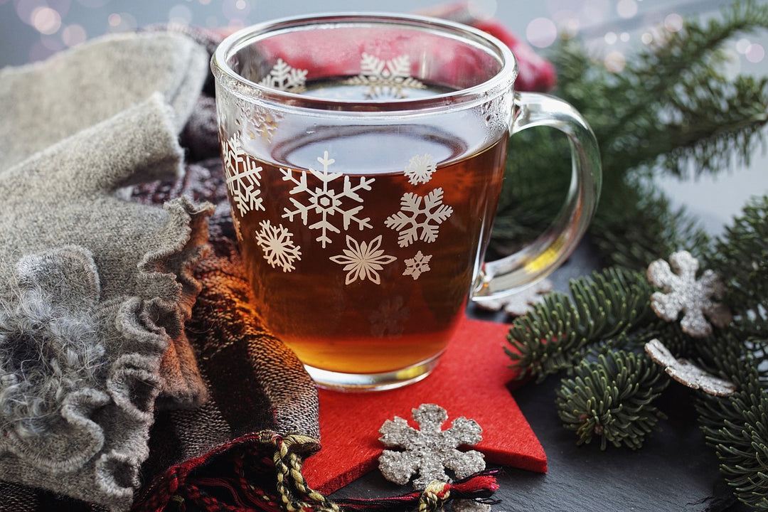 A cup of Christmas tea in a clear glass cup