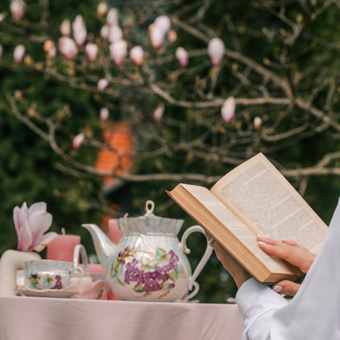 A steaming cup of organic Earl Grey tea next to a classic mystery novel on a wooden table.